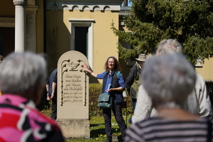 Frau Böttcher erläutert Symbole an Grabstele aus der Biedermeierzeit