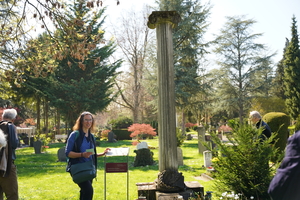Frau Böttcher vor repräsentativem Grabmal für Dr. Carl Friedrich, Gymnasialrektor, von 1904: hohe ionische Säule mit Lorbeerkranz.